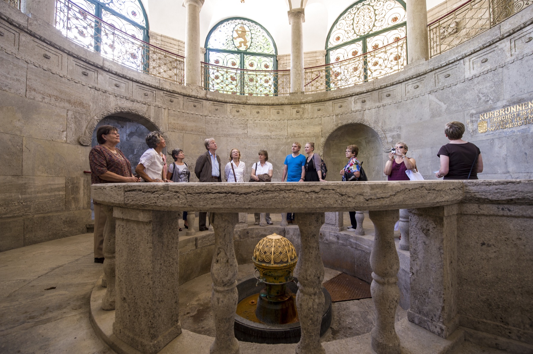 A guided tour group around the historic Kurbrunnen fountain in Bad Nauheim